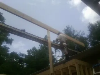 Carpenter setting a ridge beam over a new addition frame — Ice Dam Removal by Roofing Brothers in Dumont